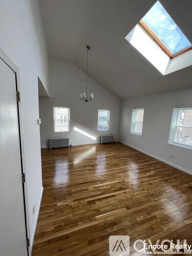 A room with wooden floors and skylight.