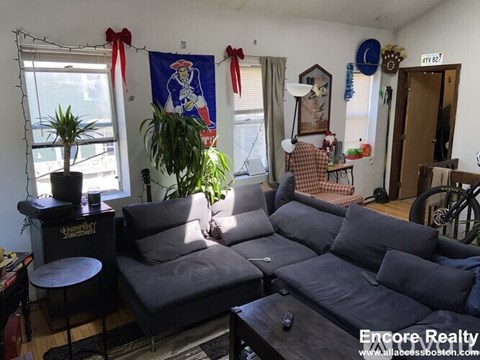 A living room with a grey couch and a wooden coffee table.