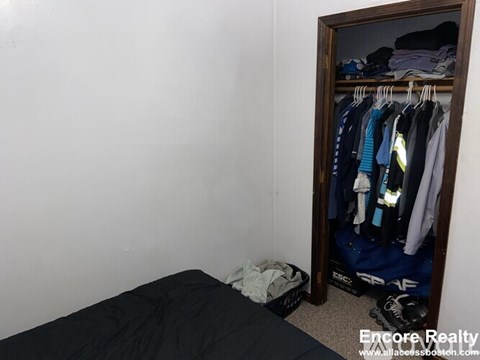 A bedroom with a bed, a wardrobe and a mirror.