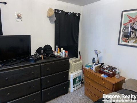 A black dresser with a TV on top of it in a room.