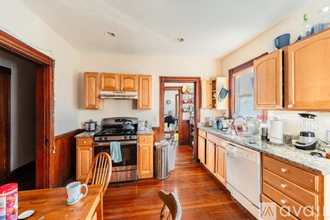 A kitchen with wooden cabinets and a wooden table with a mug on it.