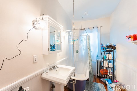 A bathroom with a sink, mirror, and shower.