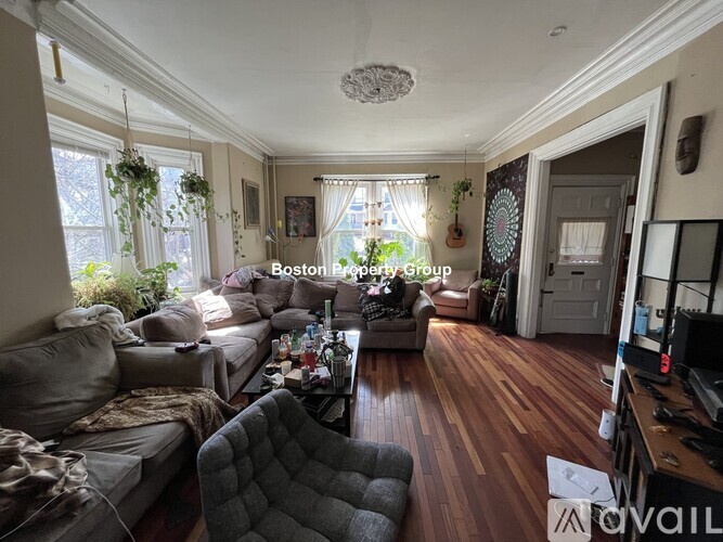 A living room with a grey couch and a wooden floor.