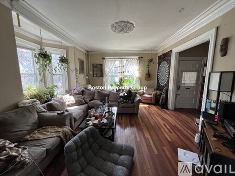 A living room with a grey couch and a wooden floor.