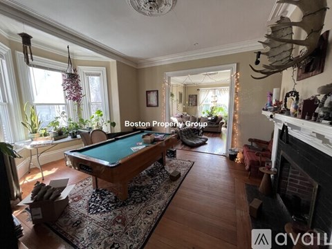 A room with a pool table and a fireplace.