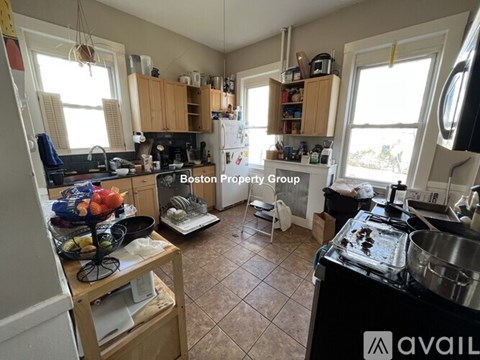 A kitchen with a black stove top oven and wooden cabinets.