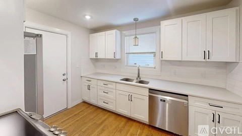 A kitchen with white cabinets and a stainless steel dishwasher.