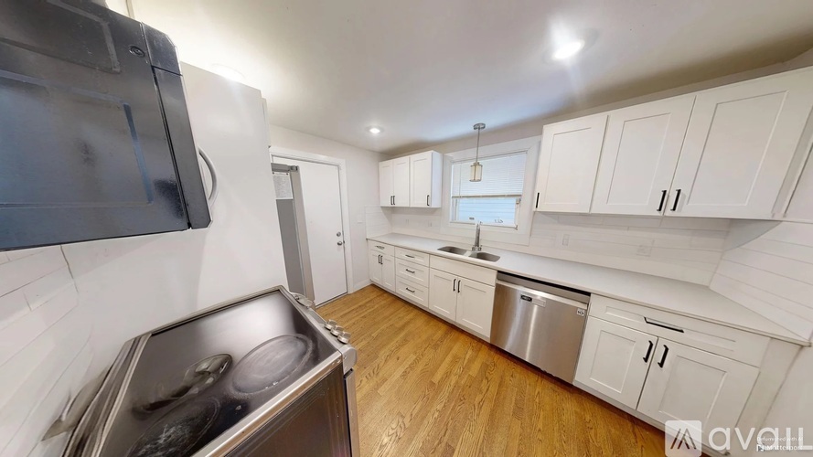 A kitchen with white cabinets and a stainless steel dishwasher.