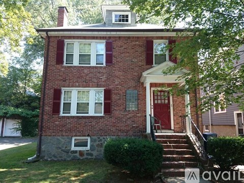 A red brick house with a white door and windows.
