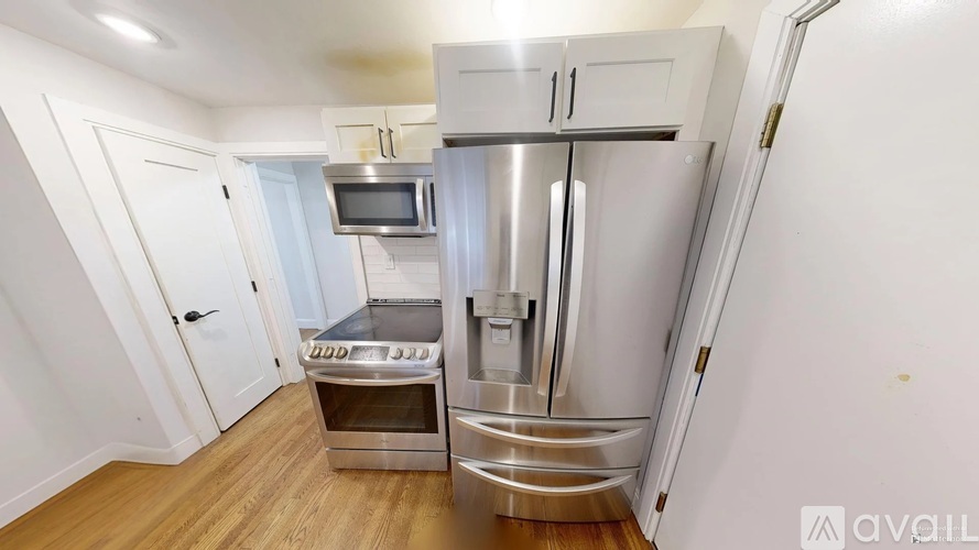 A kitchen with a stainless steel refrigerator, oven, and microwave.