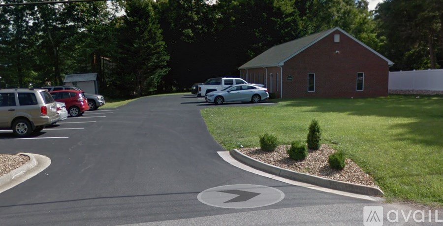 A parking lot with cars and a building in the background.