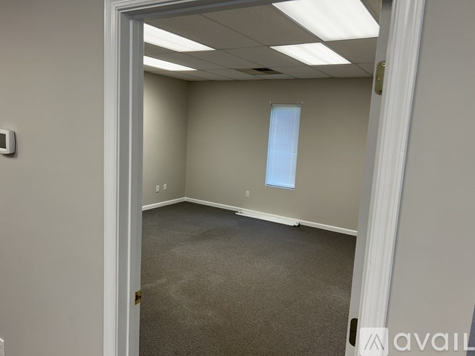 A room with a carpeted floor and a doorway leading to another room.