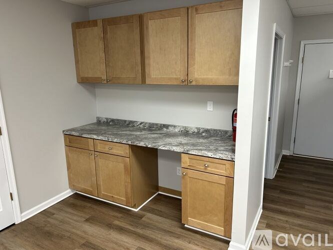 A kitchen with wooden cabinets and a marble countertop.