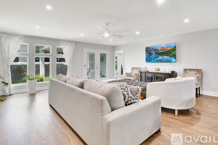 A living room with a large couch and a painting on the wall.