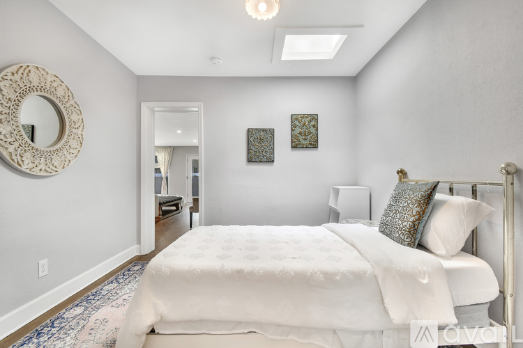 A bedroom with a large bed and a mirror on the wall.