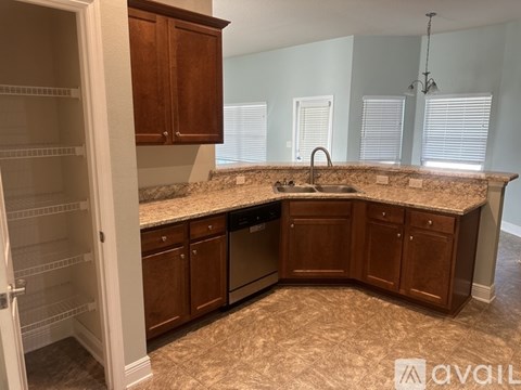 A kitchen with brown cabinets and a granite countertop.