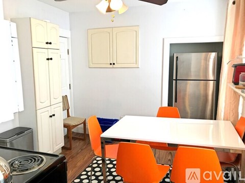 A kitchen with a table and chairs.