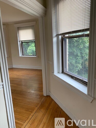 A room with wooden floors and two windows.