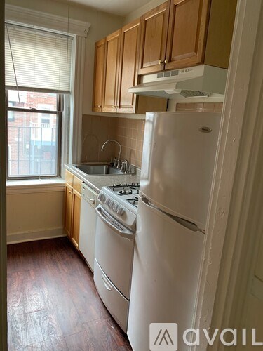A kitchen with white appliances and wooden cabinets.