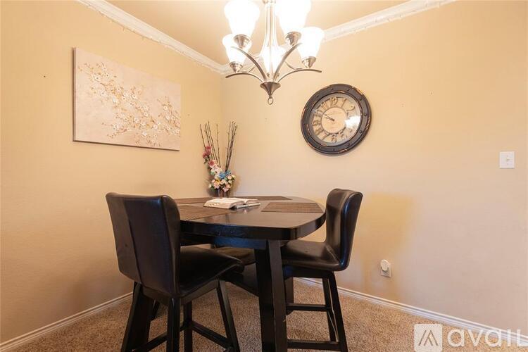 A dining room with a table, chairs and a clock on the wall.