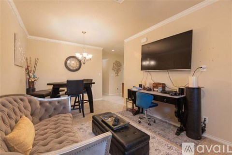 A living room with a grey couch and a black television.