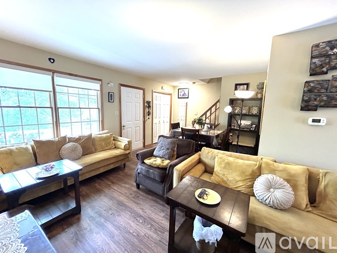 A living room with a couch, a coffee table, and a staircase.