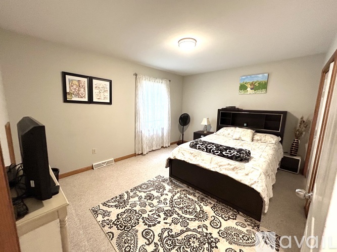 A bedroom with a large bed and a television.
