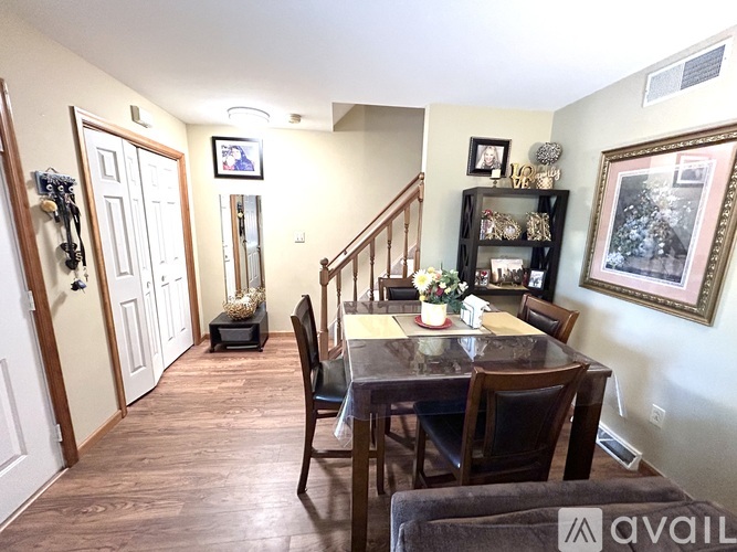 A dining room with a table set for two and a painting on the wall.
