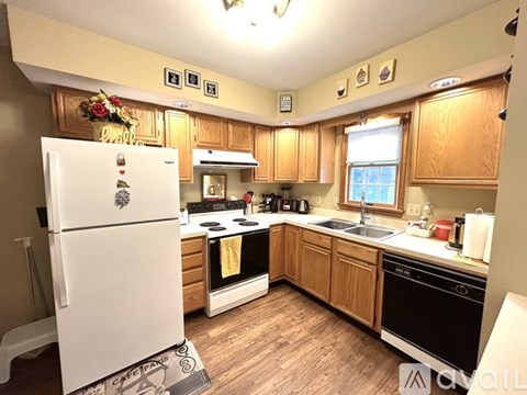 A kitchen with wooden cabinets and a white fridge.