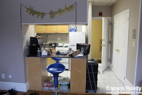 A kitchen with a birthday banner hanging above it.