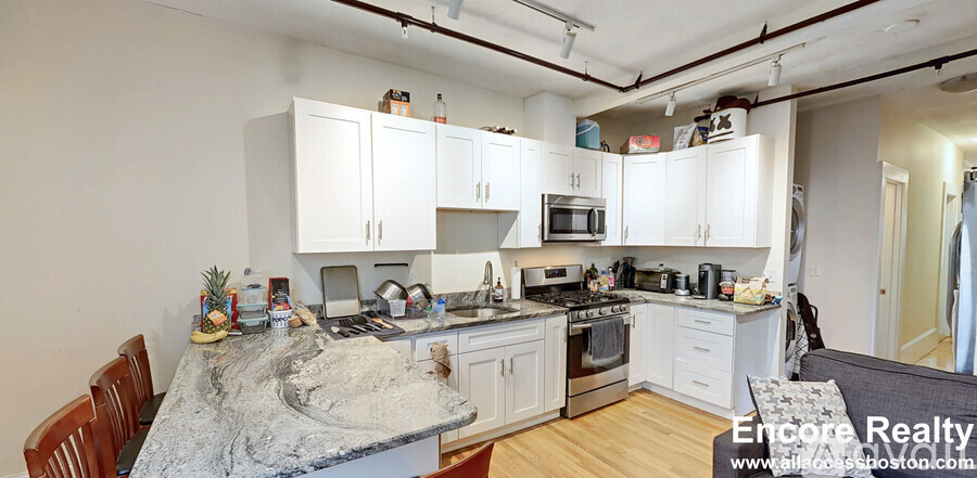 A kitchen with white cabinets and a granite countertop.