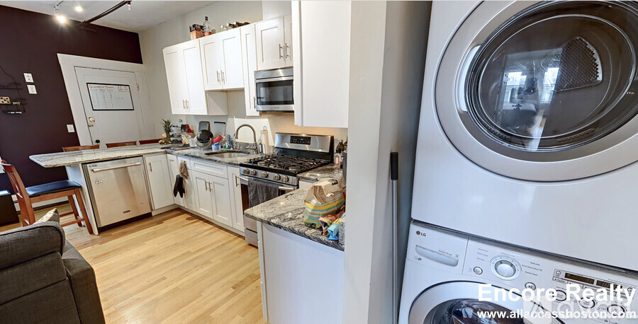 A modern kitchen with a washing machine on the right.