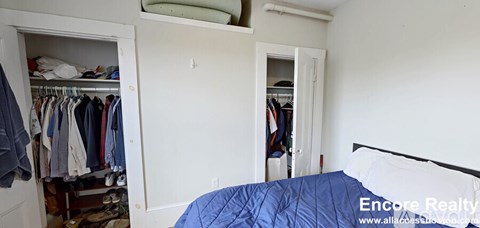 A bedroom with a bed, a wardrobe and a closet.