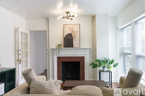 A living room with a fireplace and a painting above it.