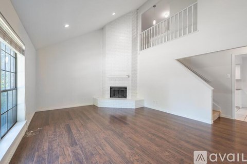 A spacious living room with a fireplace and wooden flooring.