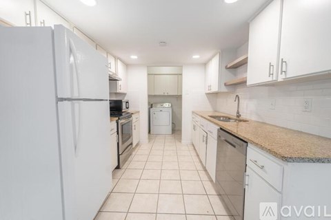 A kitchen with white appliances and cabinets.