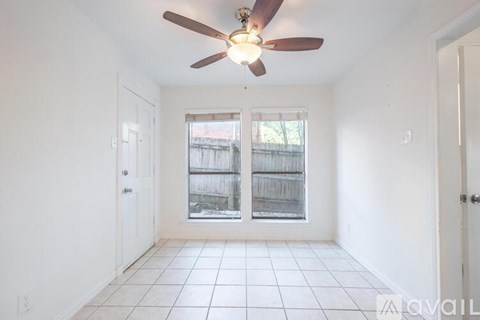 A room with a ceiling fan and tiled floor.