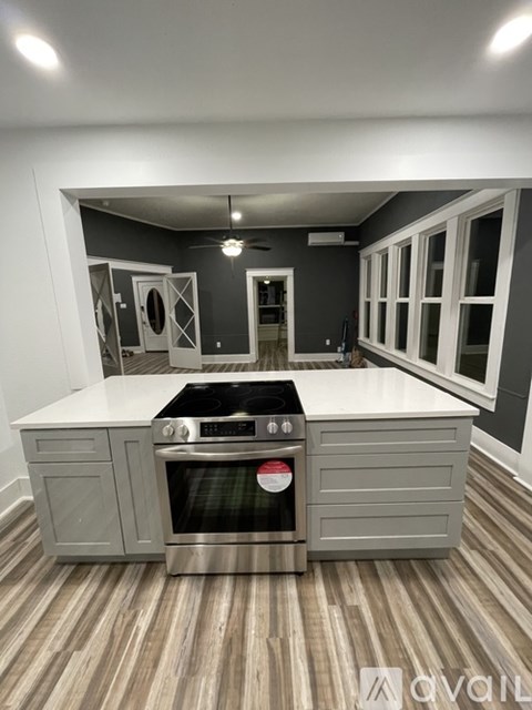 A modern kitchen with a stainless steel oven and wooden flooring.