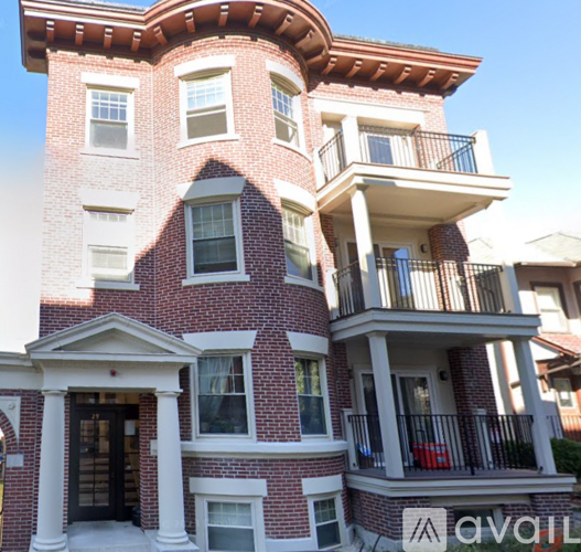 A red brick house with a balcony on the second floor.
