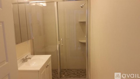 A small bathroom with a sink and a shower.