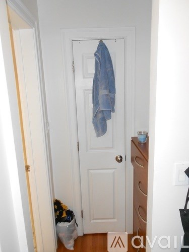 A blue shirt is hanging on a white door.