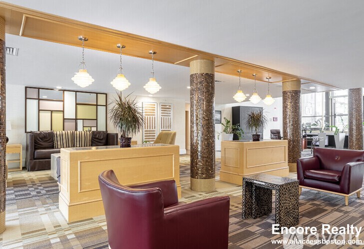 A well-lit waiting area with a wooden reception desk and comfortable seating.
