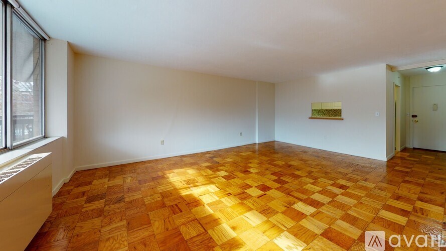 A room with wooden flooring and white walls.