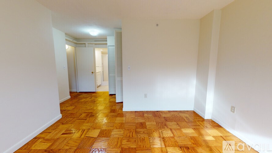 A room with wooden flooring and white walls.