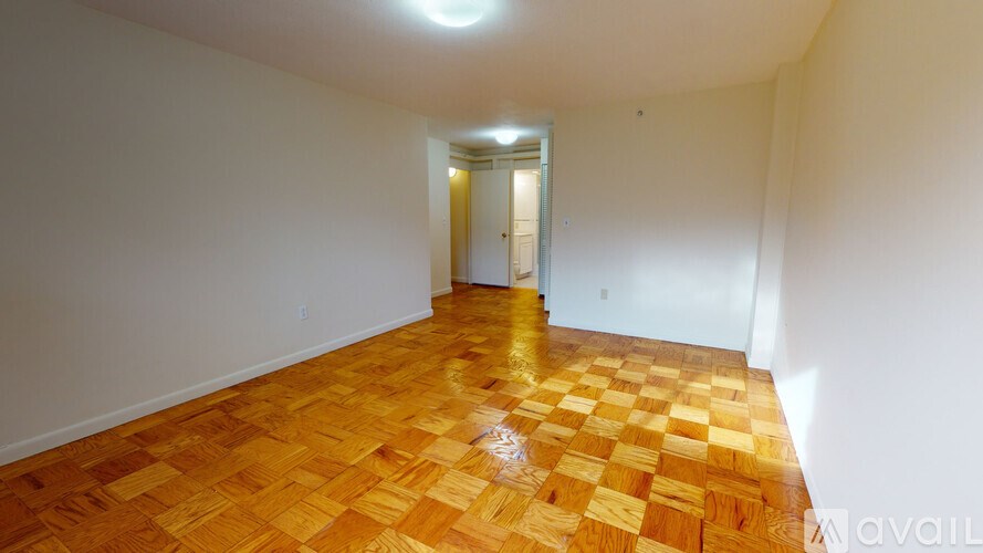 A room with wooden flooring and a doorway leading to another room.