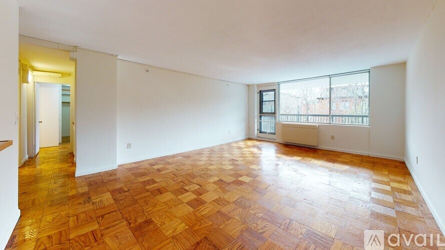 A room with wooden flooring and white walls is available for rent.