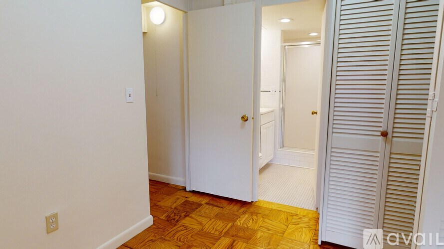 A room with a white door and a wooden floor.