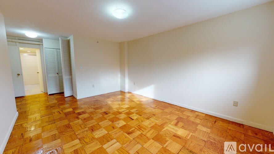 A room with wooden flooring and a door in the background.