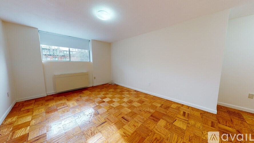 A room with wooden flooring and white walls is available for rent.