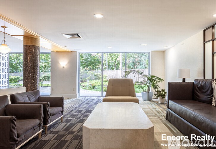 A spacious waiting area with brown leather couches and a white coffee table.